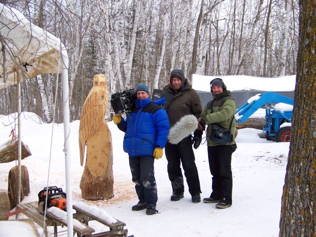 German film crew filming chainsaw carving