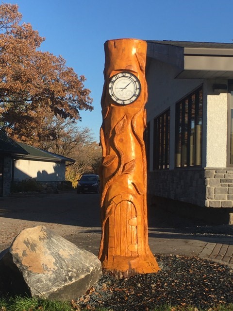 Tree clock chainsaw carving in golf coarse